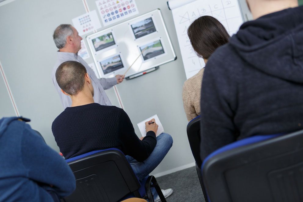 Schüler bekommen Theorieunterricht von ihrem Fahrlehrer